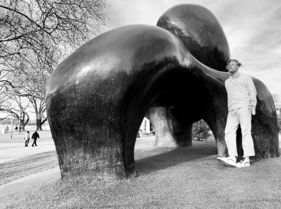Black and white image of Ryan Board with Henry Moore sculpture by the lake