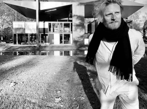 Black and white image of artist and designer Ryan Board outside Pavillon Le Corbusier
