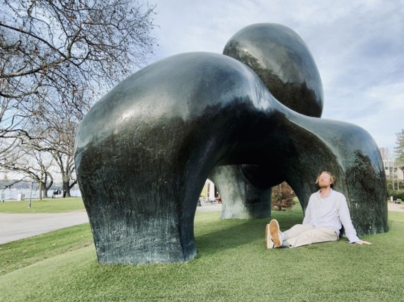 Image shows Ryan Board next to a Henry Moore sculpture on the shore of Lake Zurich