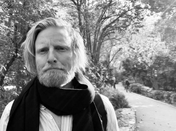 Black and white image of Artist Ryan Board filming on location in Athens